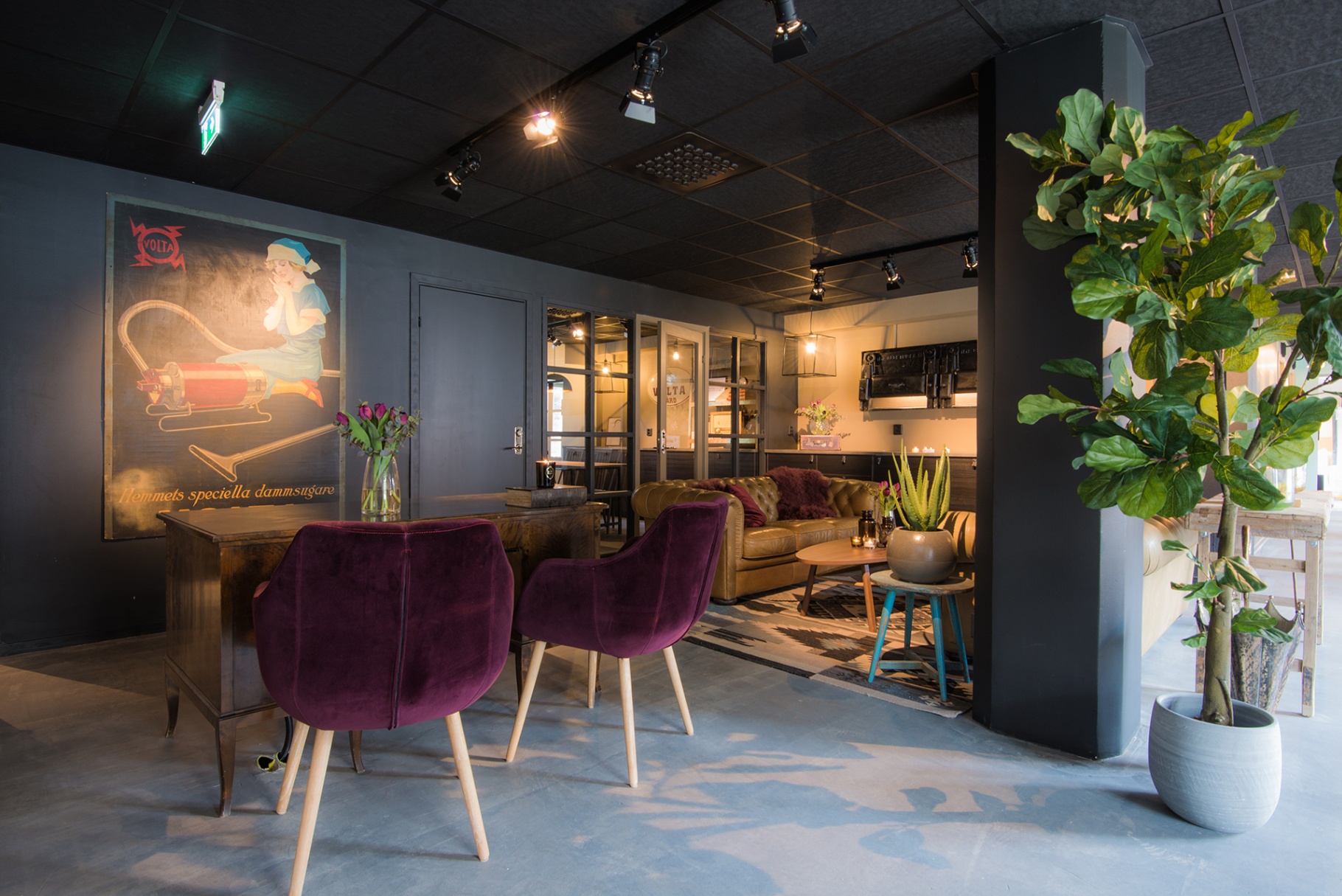 Botell Volta lobby — Volta-reklamskylt, plommonfärgade fåtöljer och chesterfield