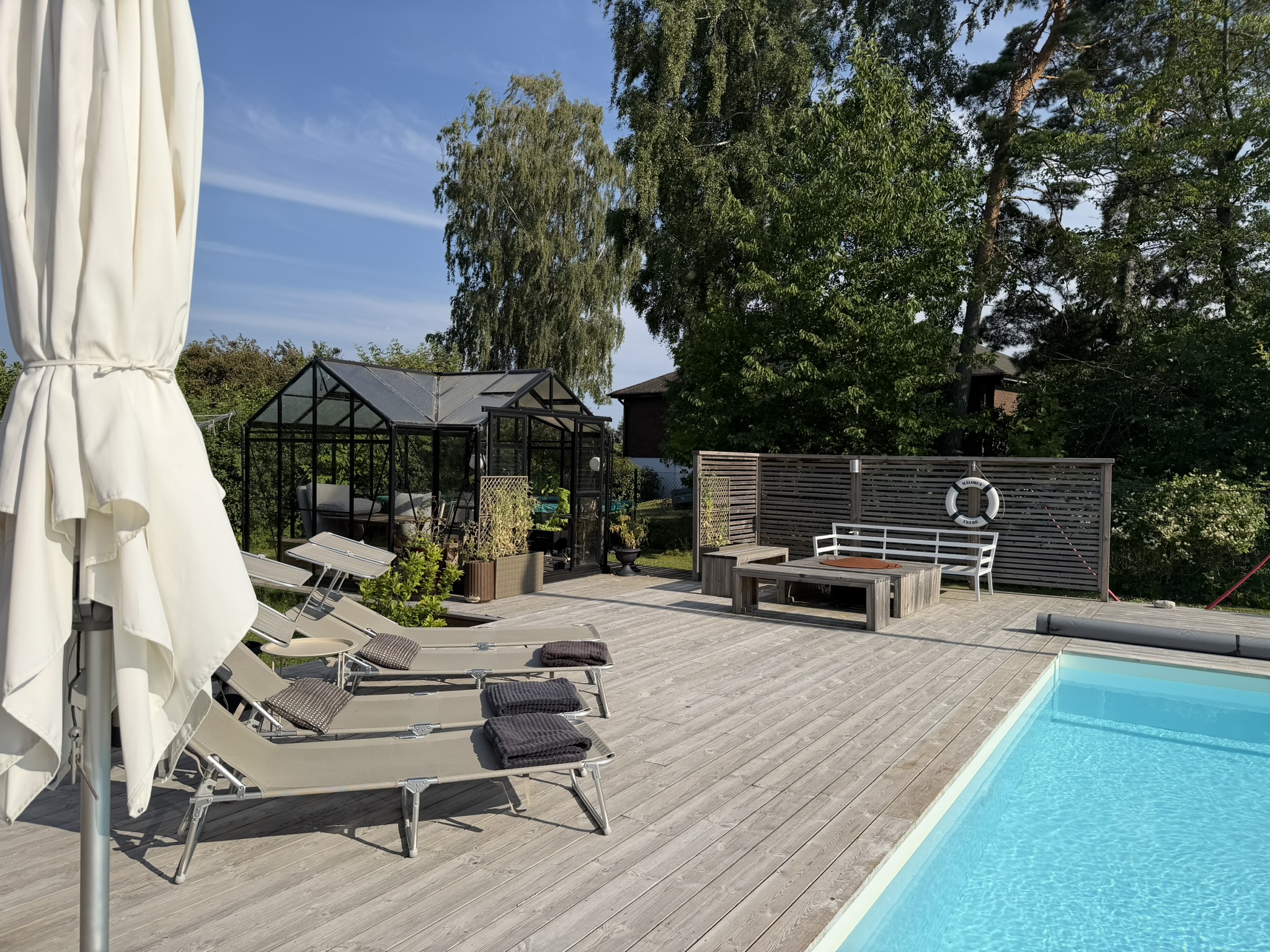 Pool, solbäddar och växthusen i morgonljus